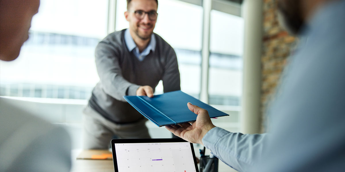 military veteran handing documents to a hiring official during a job interview