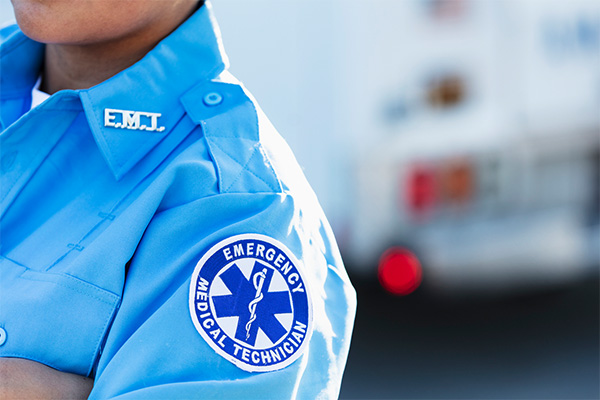 Close up image of an EMS professional's shoulder, including a patch with the words "emergency medical technician"