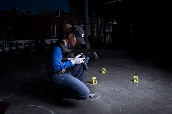 Forensics investigator photographs evidence at crime scene